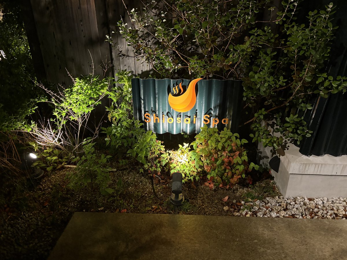 夜にライトアップされた潮騒スパの看板